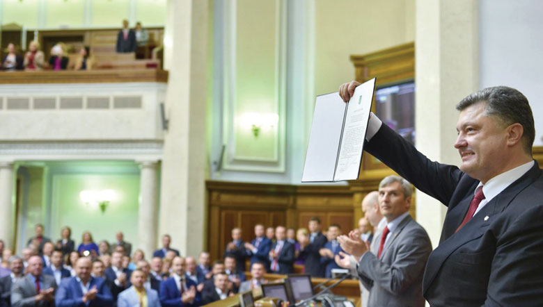 President Petro Poroshenko holds up a copy of the Ukraine-EU Association Agreement after it was ratified by the Verkhovna Rada on September 16.