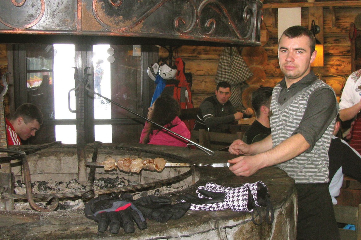 A cook roasts shashlyky (kebabs) at the indoor grill at Korchma Filvarok on Mount Bukovel.