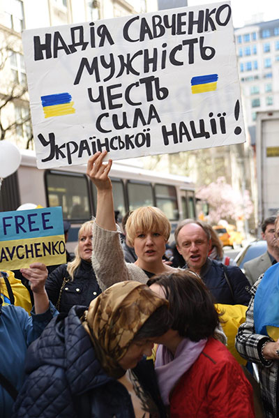 A rally participant’s sign reads: “Nadiya Savchenko: courage, honor, strength of the Ukrainian nation.”