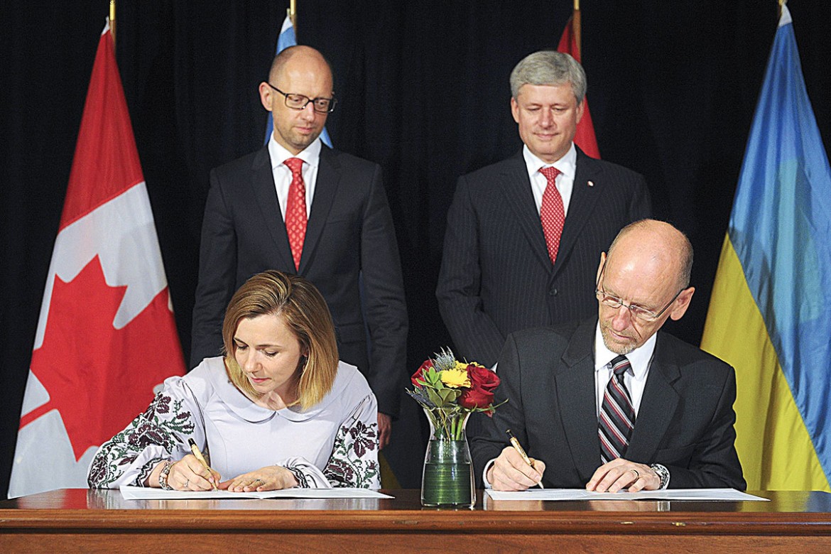 The Canada-Ukraine Free Trade agreement is signed by Ukraine’s trade representative Nataliya Mykolska, and Marvin Hildebrand, representative of Foreign Affairs, Trade and Development Canada, as the prime ministers of the two countries look on.