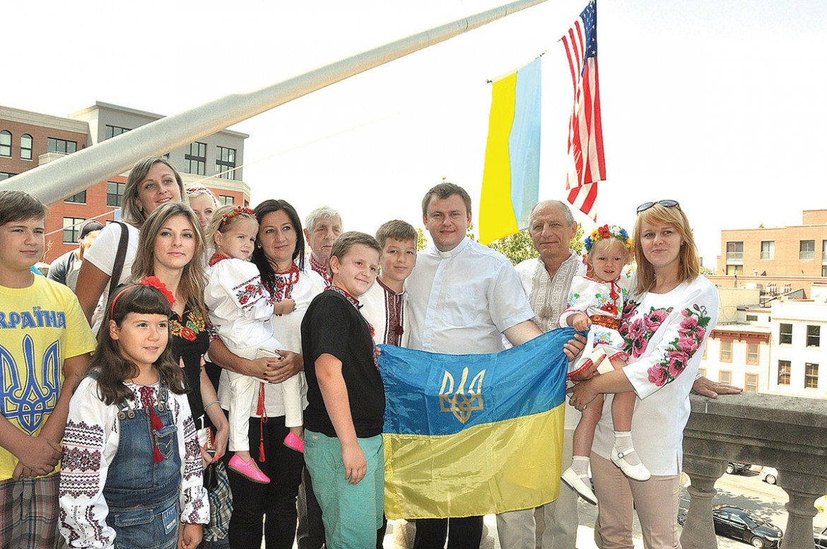 Ukrainians of all ages raise the blue-and-yellow flag at City Hall.