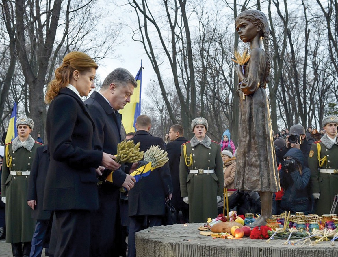 President Petro Poroshenko and First Lady Maryna Poroshenko place symbolic bouquets of wheat before the statue named “The Sad Memory of Childhood,” which is part of the national museum complex dedicated to the memory of Holodomor victims.