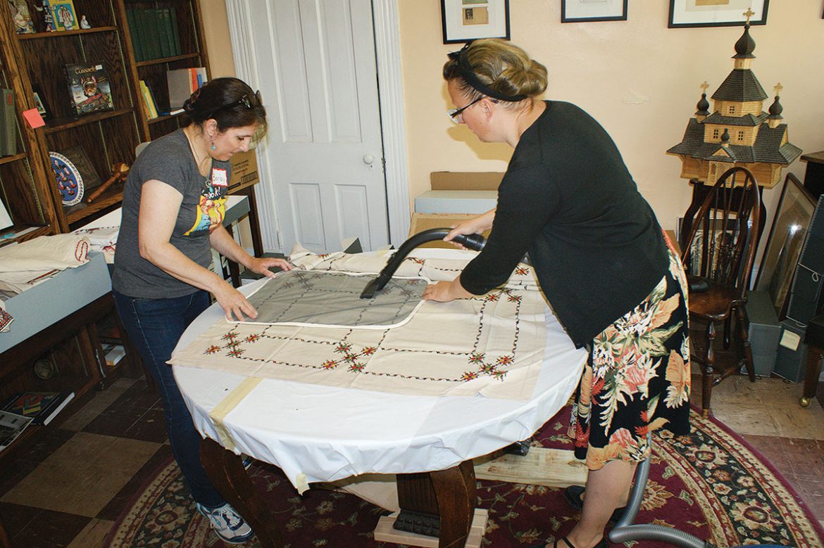 Vacuuming an embroidered cloth. In all, CSA conservators prepared more than 300 items for storage in acid-free containers. 
