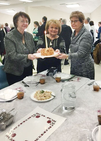 Linda Hippel, Olga Tchir and Dorothy Rygiel place the kolach on the table.