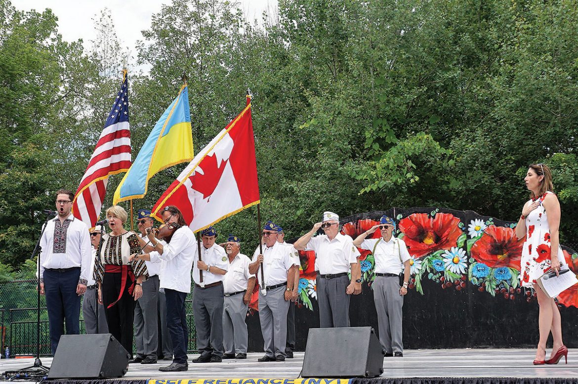 During the opening ceremonies, (from left) Andrij Gavdanovich, Swiatoslava Kaczaraj and Vasyl Popadiuk perform the national anthems of the United States, Canada and Ukraine with Ukrainian American Veterans serving as a color guard. On the right is MC Lydia Kulbida.