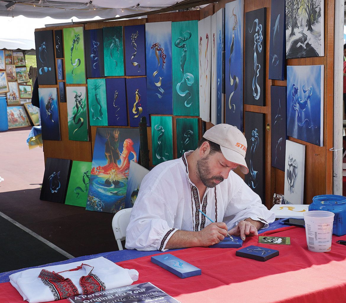 An artist produces pieces of art in front of visitors’ eyes at the vendors’ court.