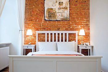 The simple yet rustic interior showing an exposed brick wall in one of the On the Square rooms located at Lviv’s centrally located Market Square. 