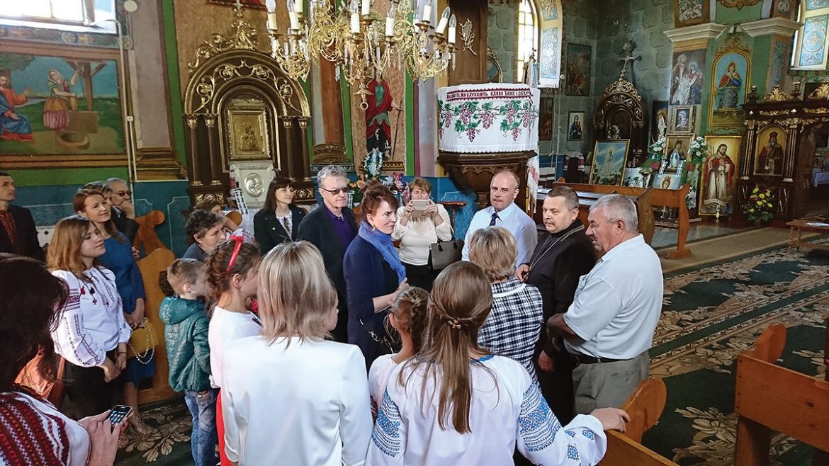 Holly Palance (center) inside the village’s Ukrainian Greek-Catholic church with her husband, Robert Wallace (left), the priest, and the mayor standing next to him on September 15.