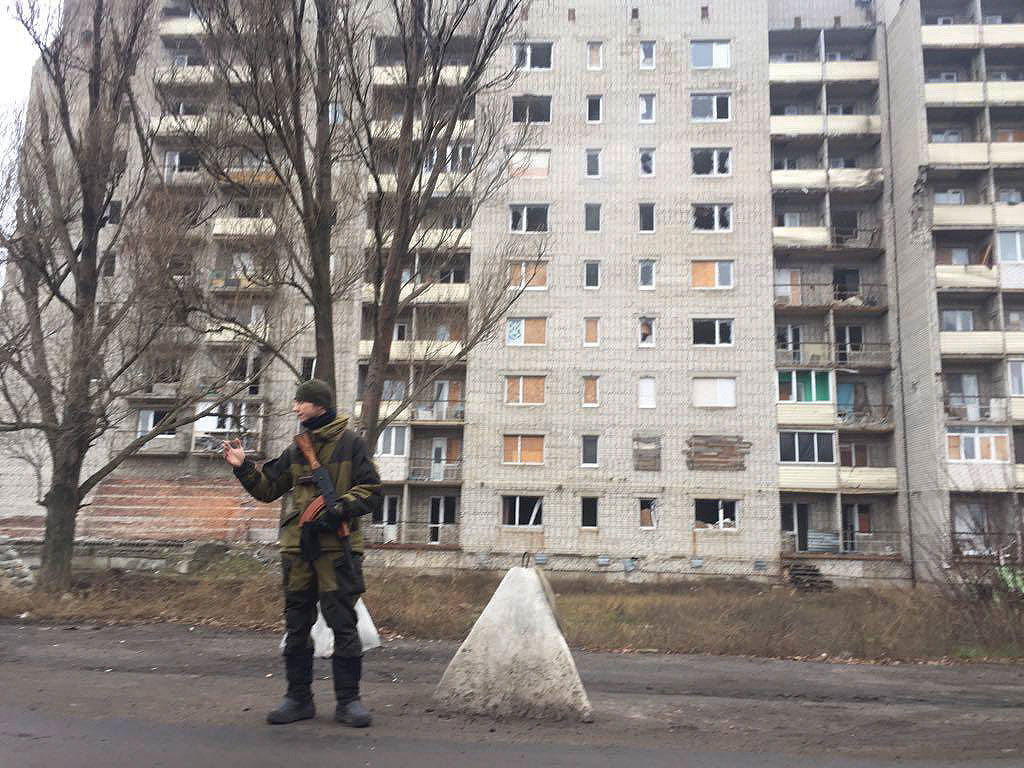 A Ukrainian soldier waves a vehicle by while guarding a checkpoint in the frontline town of Avdiyivka in Donetsk Oblast on December 4.